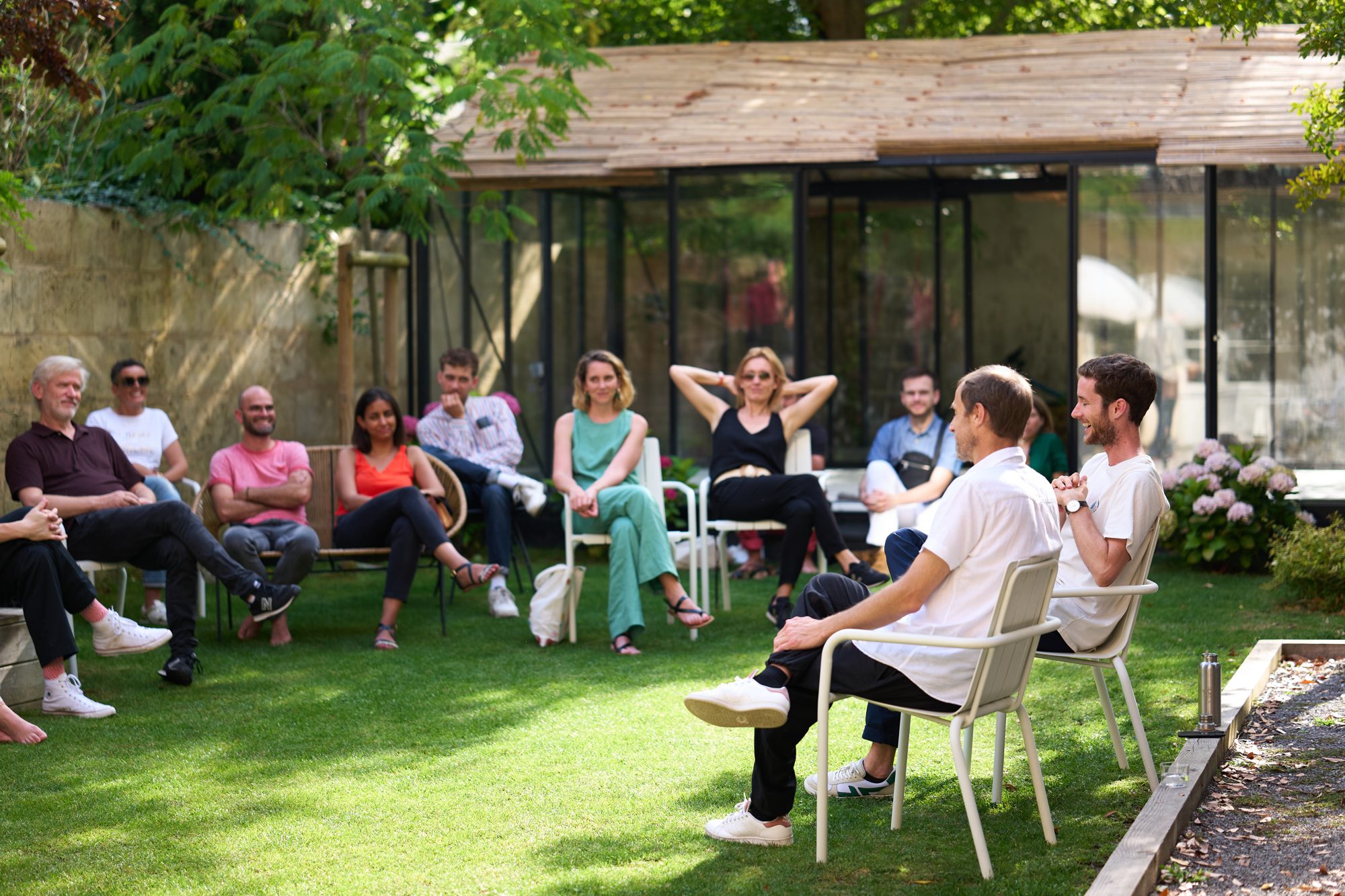 Participants réunis en cercle devant le pavillon du jardin
